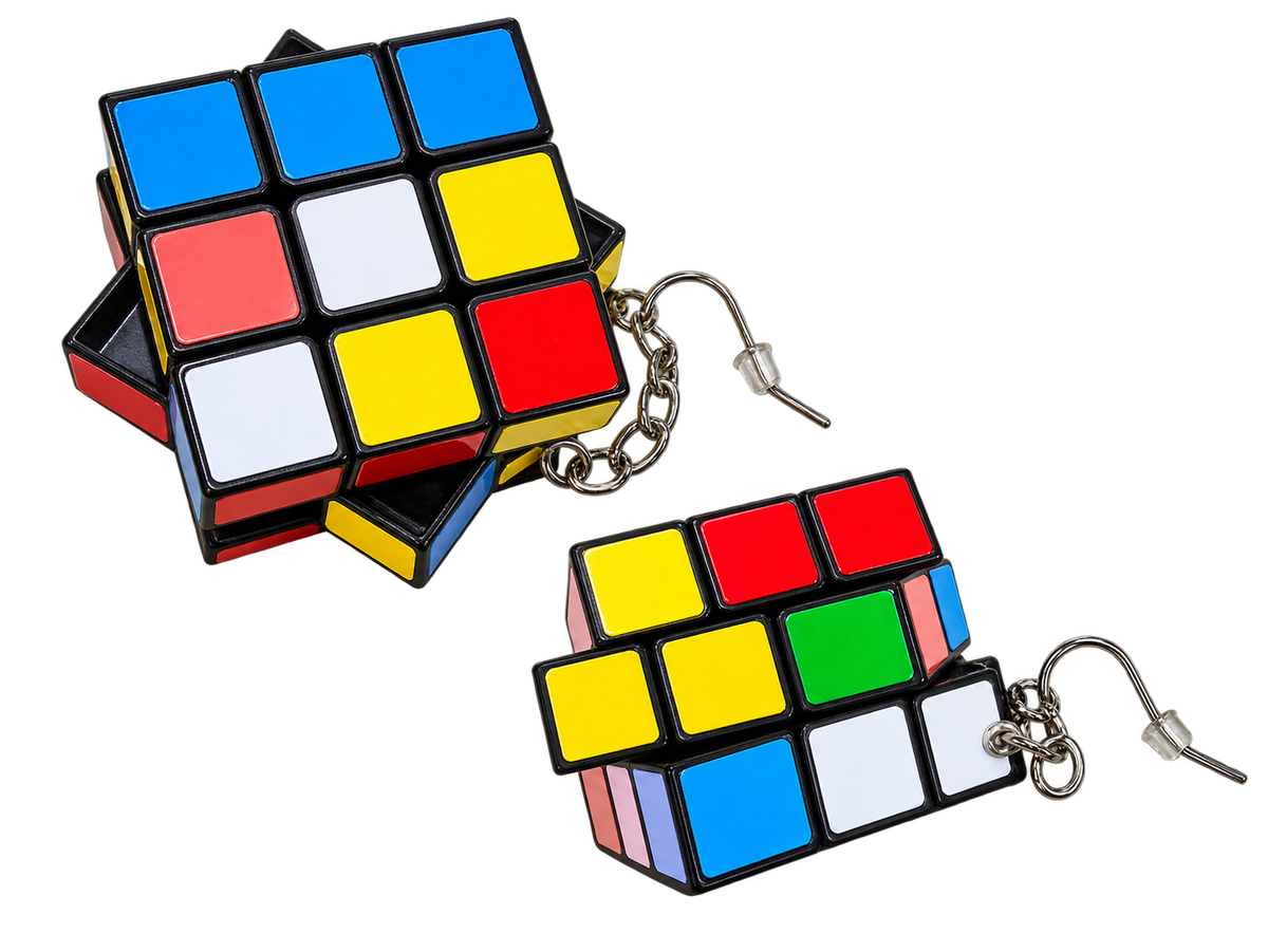 A pair of earrings shaped like twisted Rubik's cubes, with one larger intact piece and one partially disassembled showing the metal hooks and chain. The cubes have black frames with blue, red, yellow, white, and green panels on a plain white background.